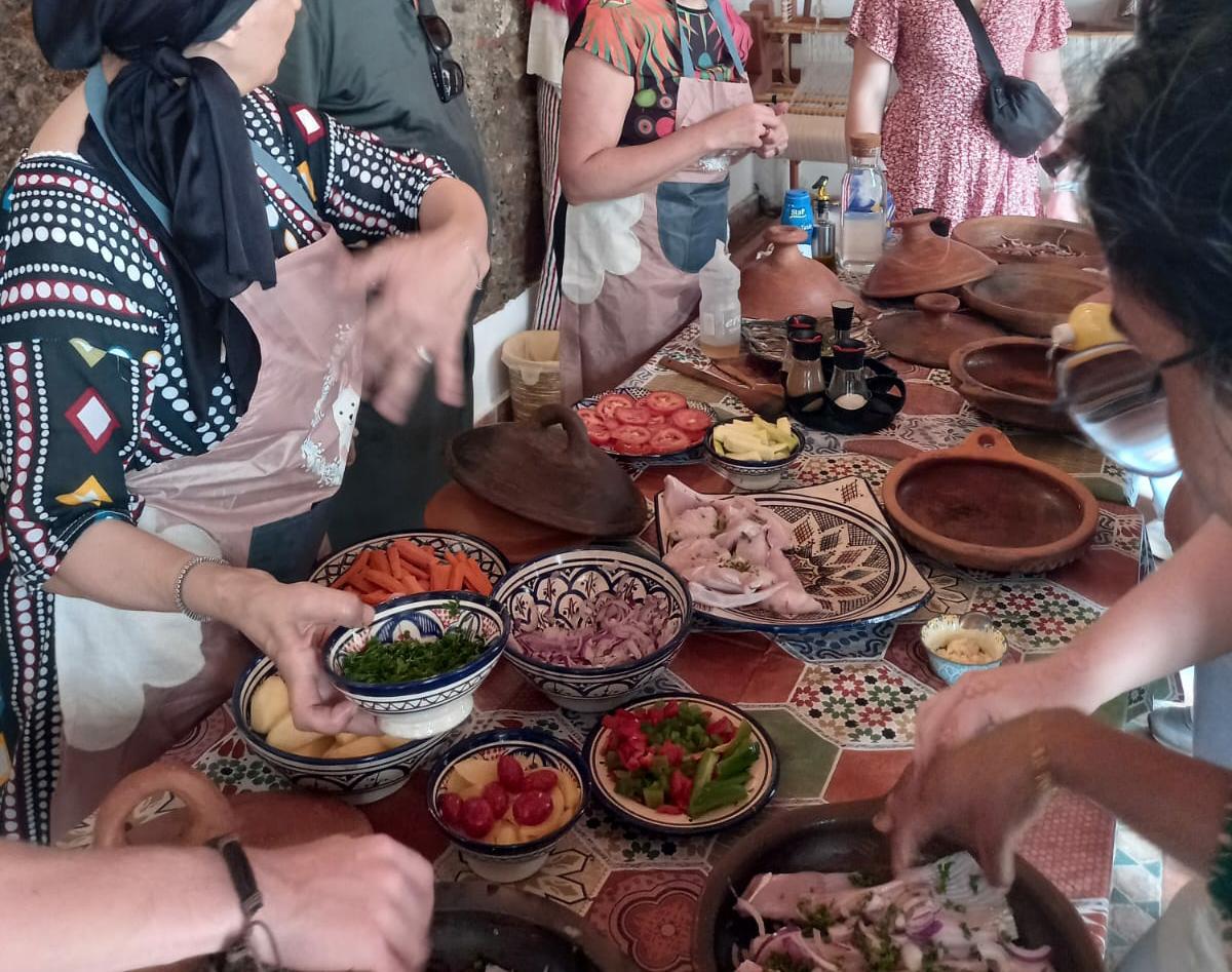 Guests gathered around a table of traditional Moroccan dishes in hand-painted ceramic bowls